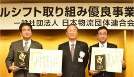 【表彰式の様子】右から YLC 取締役執行役員 池田 隆 (いけだ たかし)日本物流団体連合会 会長 工藤 泰三 (くどう やすみ) YTC 通運支店 支店長 保坂 武(ほさか たけし)